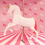 Karussell-Pferd in einem rosa gemusterten Raum im Cali Dreams Museum